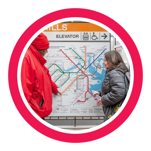 An Ambassador helping a rider read a transit map