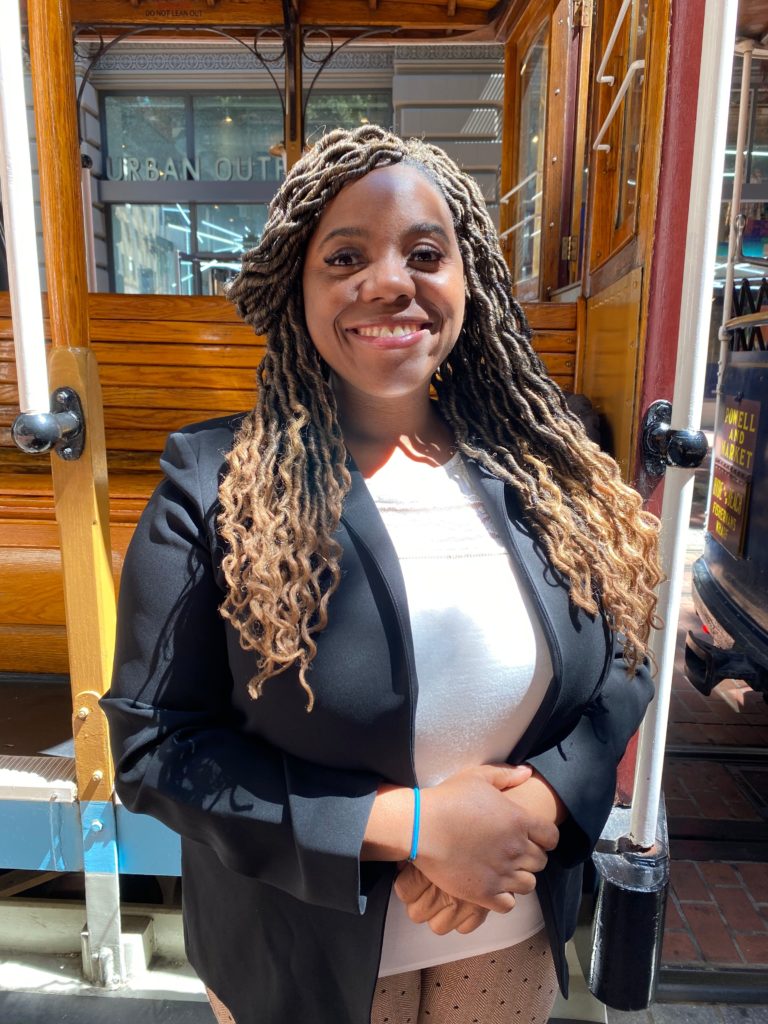 Woman in business attire smiling.