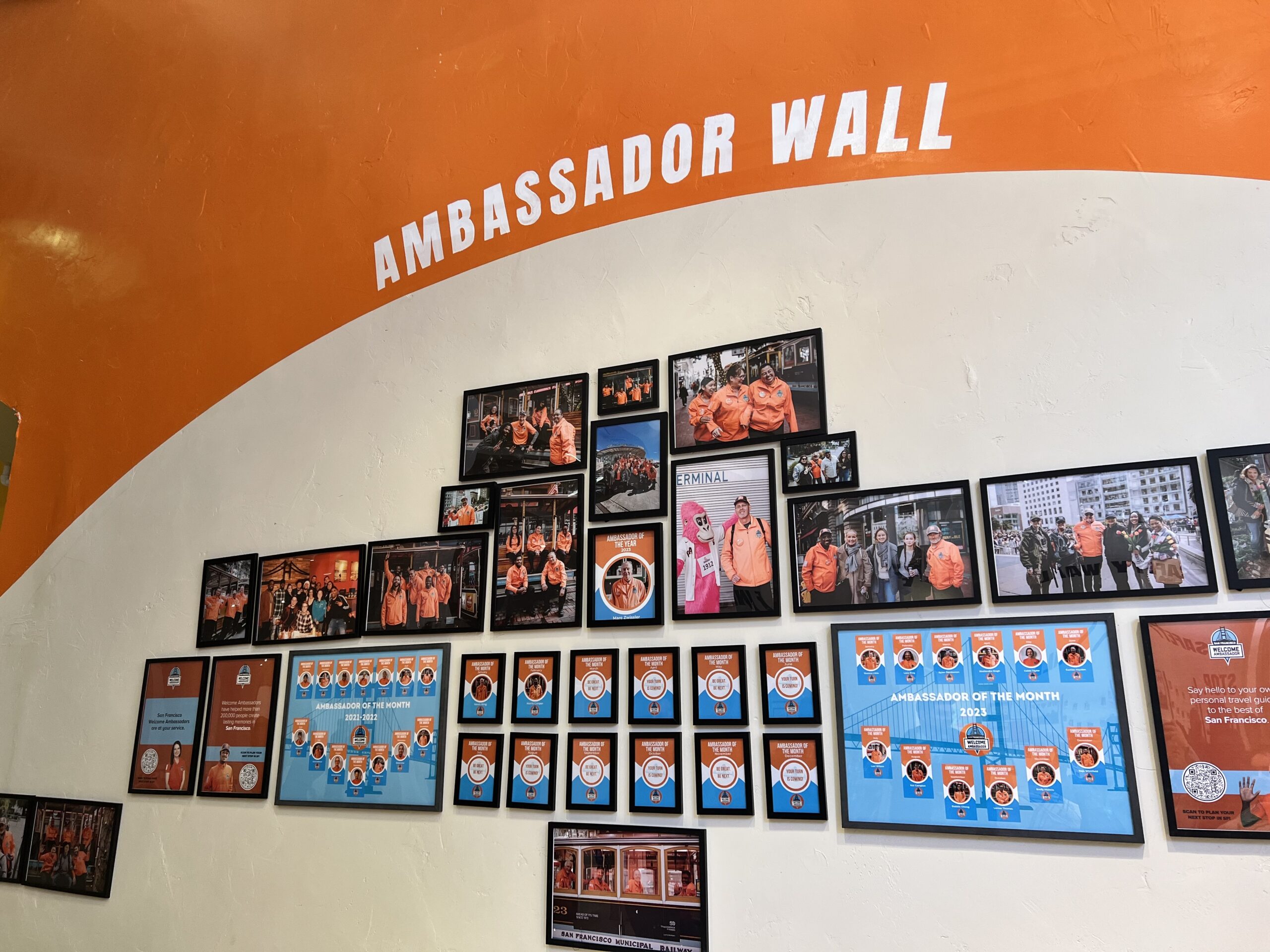 A wall of pictures and Ambassadors of the Month Headshots.